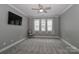 Neutral bedroom features a ceiling fan and a bank of windows for ample natural light at 3709 Creek Ridge Dr, Denver, NC 28037