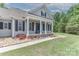 Inviting front porch with white pillars, brick accents, and a blue door, leading to a well-maintained yard at 3709 Creek Ridge Dr, Denver, NC 28037