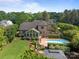 Aerial shot of backyard pool and sunroom addition to the brick home surrounded by mature trees at 389 Ponderosa Cir, Mooresville, NC 28117