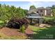View of backyard entertaining space featuring gazebo and beautiful landscaping in a park like setting at 389 Ponderosa Cir, Mooresville, NC 28117