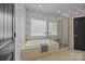 Bright bathroom featuring a soaking tub, glass shower, and decorative wallpaper at 389 Ponderosa Cir, Mooresville, NC 28117
