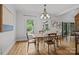 Bright dining room featuring hardwood floors, windows and an elegant chandelier at 389 Ponderosa Cir, Mooresville, NC 28117