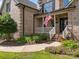 Welcoming front porch with brick facade and a trimmed walkway surrounded by colorful plants and greenery at 389 Ponderosa Cir, Mooresville, NC 28117