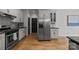 Spacious kitchen boasts stainless steel appliances, white cabinets, and hardwood flooring at 389 Ponderosa Cir, Mooresville, NC 28117