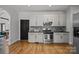 Well-lit kitchen featuring white cabinets, stainless steel appliances, and hardwood floors at 389 Ponderosa Cir, Mooresville, NC 28117