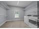 Spacious laundry room with washer, dryer, shelving, and a window at 389 Ponderosa Cir, Mooresville, NC 28117