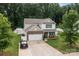 Aerial view of a two-story home with a long driveway and a fenced backyard at 413 Wheat Field Dr, Mount Holly, NC 28120