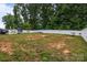 A partially-grassed backyard has a white fence and features some playground equipment at 413 Wheat Field Dr, Mount Holly, NC 28120
