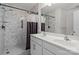 Bathroom featuring a double sink vanity and a walk-in shower with patterned walls at 413 Wheat Field Dr, Mount Holly, NC 28120