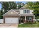 Attractive two-story home with stone accents, a two-car garage, and a welcoming front porch at 413 Wheat Field Dr, Mount Holly, NC 28120
