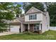 Charming two-story home featuring stone accents, a cozy front porch, and well-manicured lawn at 413 Wheat Field Dr, Mount Holly, NC 28120