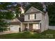 Charming two-story home featuring stone accents, a cozy front porch, and well-manicured lawn at 413 Wheat Field Dr, Mount Holly, NC 28120