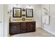 Bathroom with double sinks, dark cabinetry, granite countertops, and decorative mirrors at 4151 Green Park Ct, Harrisburg, NC 28075