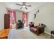 Spacious bedroom with a ceiling fan, large windows with red curtains, and a brown leather chair at 4151 Green Park Ct, Harrisburg, NC 28075