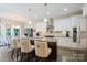 The bright kitchen features white cabinets, stainless steel appliances, granite counters, and an island with seating at 4151 Green Park Ct, Harrisburg, NC 28075