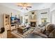 Comfortable living room boasts a fireplace, ceiling fan, decorative shelving, and large windows for natural light at 4151 Green Park Ct, Harrisburg, NC 28075