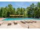 Community pool with lounge chairs, shaded area, and mature trees surrounding at 4151 Green Park Ct, Harrisburg, NC 28075