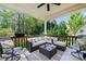 Cozy covered porch with cushioned seating, ceiling fan, and wooded views at 4151 Green Park Ct, Harrisburg, NC 28075