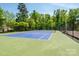 Community tennis court with green and blue surface surrounded by tall trees at 4151 Green Park Ct, Harrisburg, NC 28075