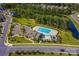 Aerial view of a community pool, with a pool house and plenty of parking near a pond at 515 Lizzie Ln, Fort Mill, SC 29708