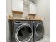 Convenient laundry room with modern washer and dryer, complemented by white upper cabinets and a wood countertop at 515 Lizzie Ln, Fort Mill, SC 29708