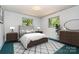 Comfortable bedroom featuring neutral walls, modern furnishings, and natural light from two windows at 52 September Ct, Concord, NC 28025