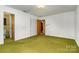 A bedroom with green carpet, white walls, multiple closets, and an attached bathroom at 52 September Ct, Concord, NC 28025