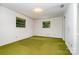 A bedroom with two windows and ample natural light, white walls and textured green carpet at 52 September Ct, Concord, NC 28025