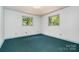 A bedroom with two windows, white walls, and blue carpeting, providing a bright and comfortable space at 52 September Ct, Concord, NC 28025