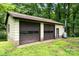 Exterior view of a two-door garage with light yellow siding, and an additional propane tank at 52 September Ct, Concord, NC 28025