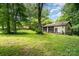 Exterior view of a two-door garage surrounded by lush trees and greenery at 52 September Ct, Concord, NC 28025