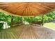 Outdoor gazebo with wooden deck, surrounding trees, and bench seating with views of the landscape at 52 September Ct, Concord, NC 28025