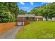 Charming brick home with manicured hedges, garage and covered porch with furniture at 648 Odell School Rd, Concord, NC 28027