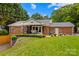 A large brick home featuring a covered back porch, a well-kept yard and mature trees at 648 Odell School Rd, Concord, NC 28027
