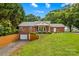 Picture of the brick home with manicured hedges, garage, and covered porch with furniture at 648 Odell School Rd, Concord, NC 28027