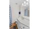 Well-lit bathroom with white vanity, patterned blue shower curtain and neutral walls at 648 Odell School Rd, Concord, NC 28027