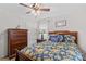 Bedroom features a floral bedspread, a ceiling fan, and matching wooden furniture at 648 Odell School Rd, Concord, NC 28027