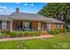 Charming brick home with black shutters, a covered porch, and well-manicured front yard at 648 Odell School Rd, Concord, NC 28027