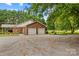 Side view of the brick house with a two car garage and a gravel driveway at 648 Odell School Rd, Concord, NC 28027