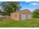 Large detached two-car garage with ample yard space and a seating area on a sunny day at 648 Odell School Rd, Concord, NC 28027