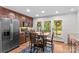 Kitchen featuring a dining table, brown cabinetry, stainless steel appliances, and a view of the outdoor patio at 648 Odell School Rd, Concord, NC 28027