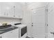 White laundry room with white cabinets, new washer and dryer, and a gray floor at 648 Odell School Rd, Concord, NC 28027