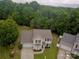 Aerial view of a two-story home surrounded by lush greenery and trees in a wooded area at 6608 Pattonsburg Dr, Charlotte, NC 28213