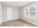A bright bedroom with a window, door, and neutral walls, showcasing an inviting atmosphere at 6608 Pattonsburg Dr, Charlotte, NC 28213
