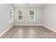 An airy bedroom with natural light flowing through two windows, highlighting the hardwood floors at 6608 Pattonsburg Dr, Charlotte, NC 28213