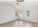 Bright bedroom features a ceiling fan, hardwood floors, and three windows that provide ample natural light at 6608 Pattonsburg Dr, Charlotte, NC 28213