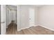 A bedroom with an open door, revealing a hallway, and featuring hardwood flooring at 6608 Pattonsburg Dr, Charlotte, NC 28213