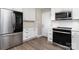 Updated kitchen with stainless steel appliances, white cabinets, and wood-look flooring at 6608 Pattonsburg Dr, Charlotte, NC 28213