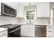 Modern kitchen with white cabinets, stainless steel appliances, and a window over the sink at 6608 Pattonsburg Dr, Charlotte, NC 28213
