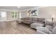 Cozy living room with gray sofa, ottoman, wood floors, and ample natural light from the windows at 6608 Pattonsburg Dr, Charlotte, NC 28213